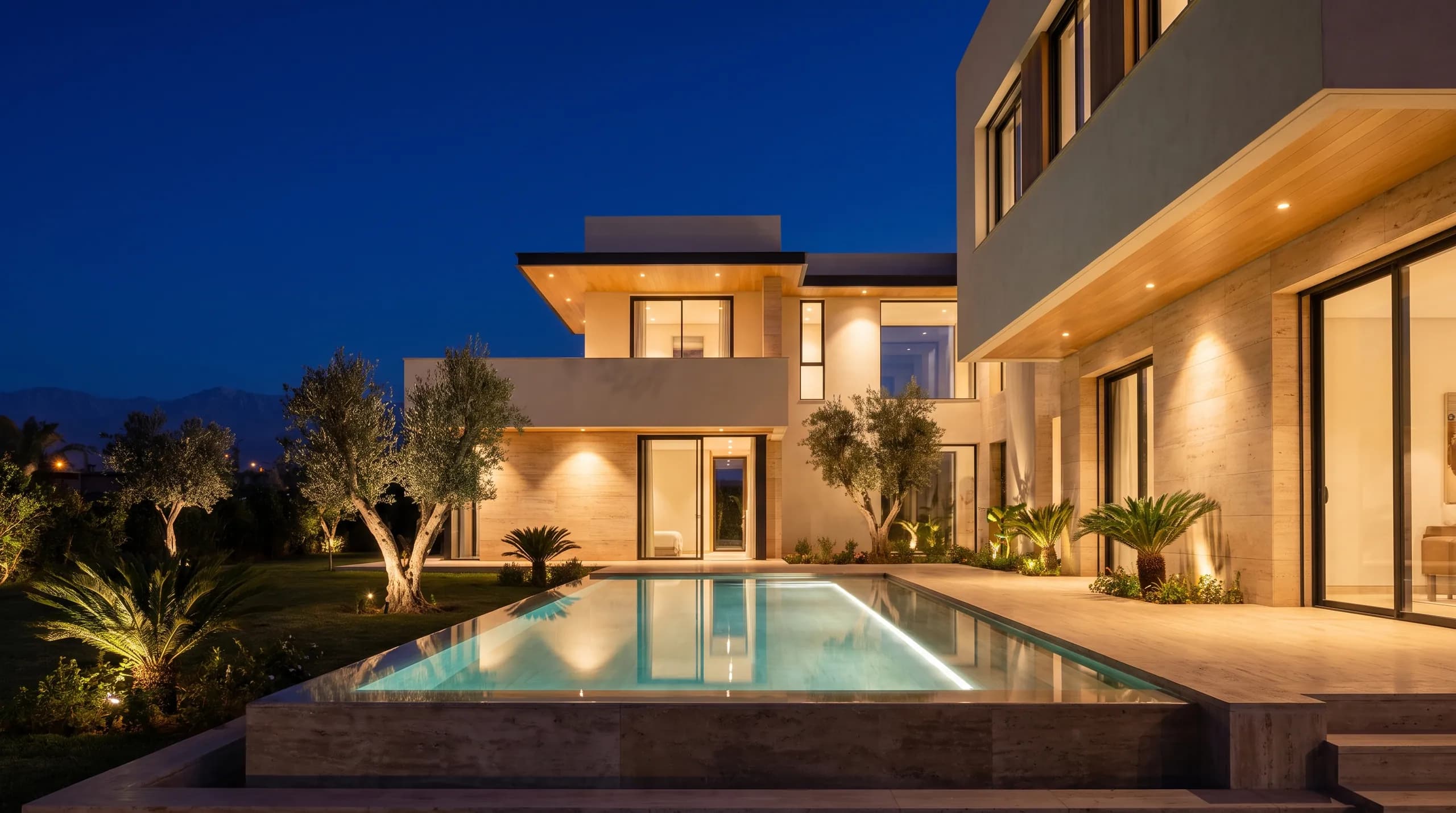 Night settling over a fully serviced villa, pool light glowing