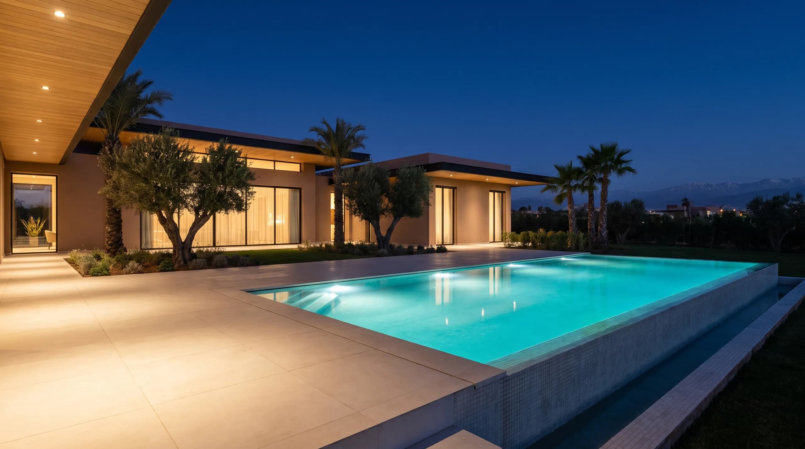 The pool glowing turquoise at night beneath the villa